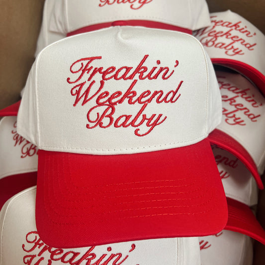Stack of white and red caps with 'Freakin' Weekend Baby' text.