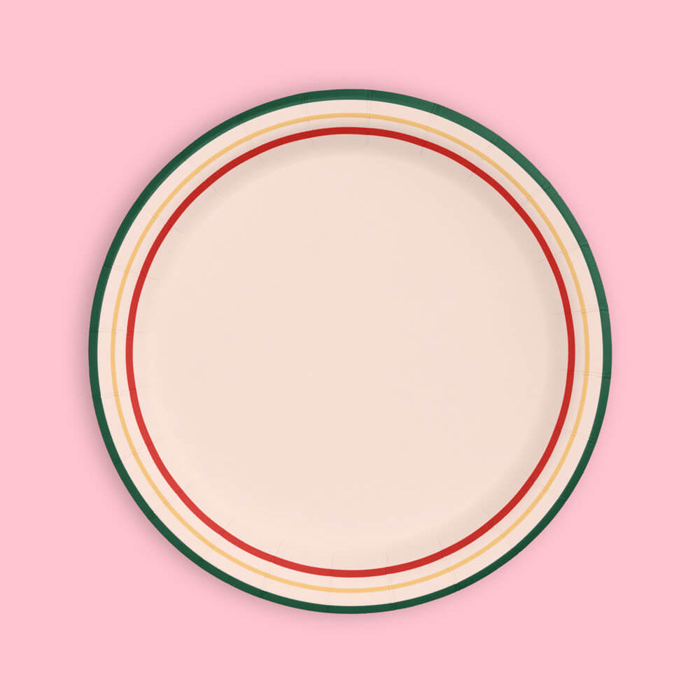 Round ceramic plate with colorful rim on a pink background