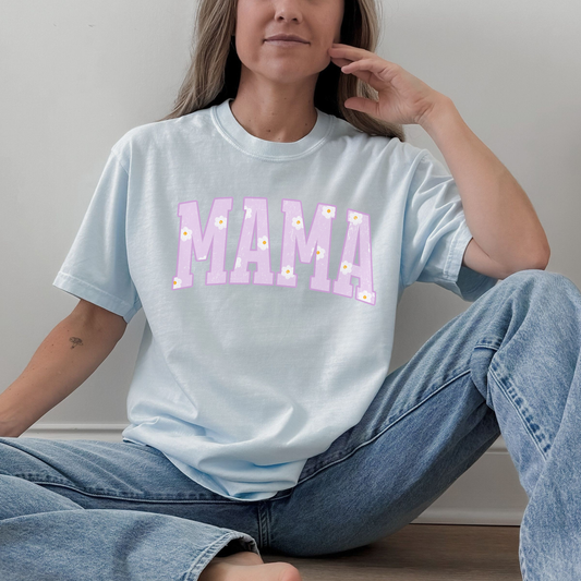 Woman wearing a light blue Comfort Colors mama graphic t-shirt with pastel purple daisy lettering, relaxed everyday style