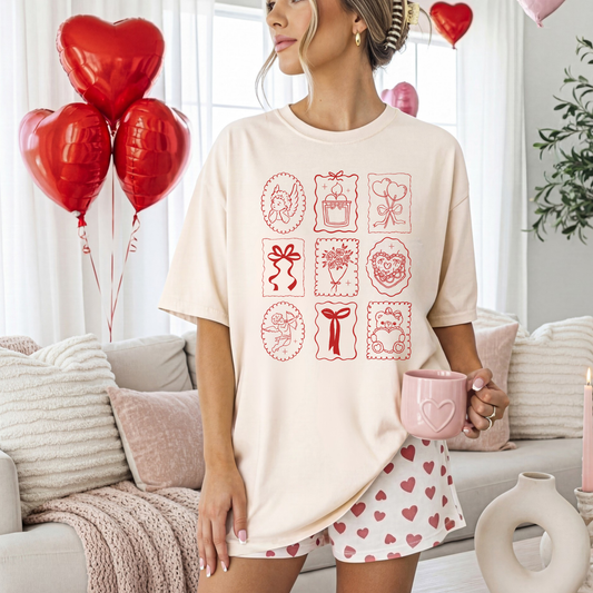 Woman wearing ivory Valentine stamp icons tee in a pink Valentine-themed room with balloons.