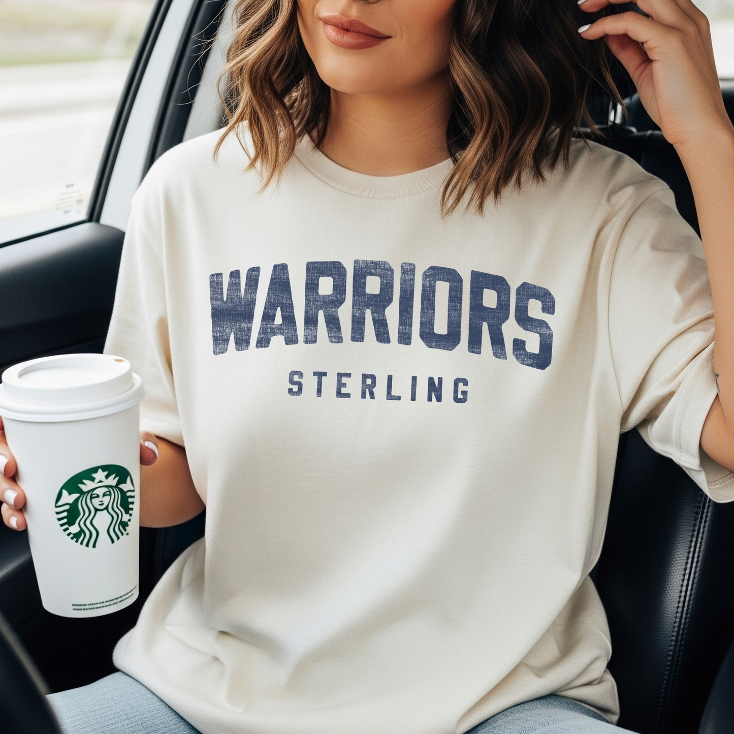 Sterling Warriors unisex graphic tee in ivory worn casually with coffee featuring bold varsity lettering
