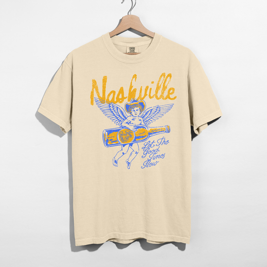 Beige Nashville graphic t-shirt with vintage angel and whiskey bottle design hanging on hanger, western aesthetic shirt