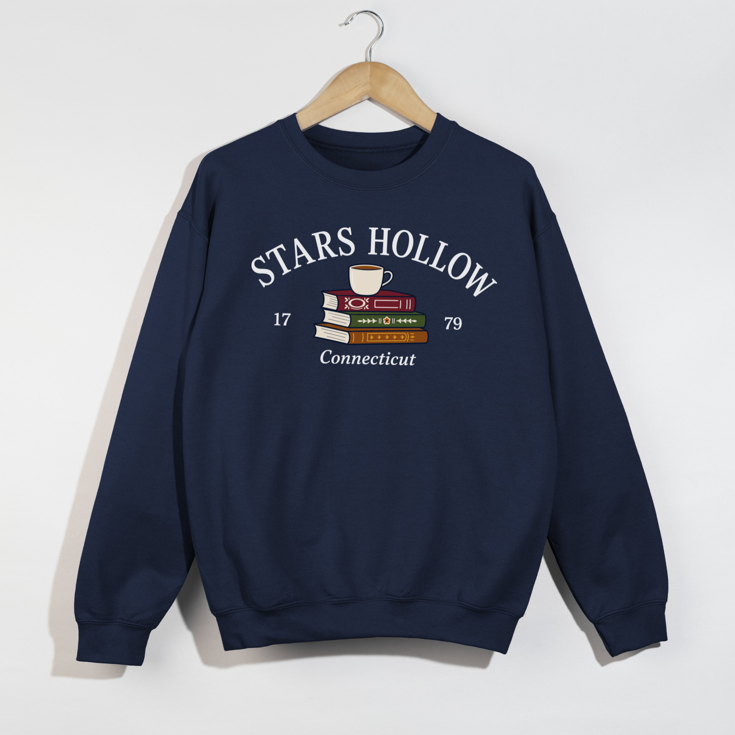 Navy Stars Hollow Connecticut crewneck sweatshirt with a cozy books and coffee graphic.