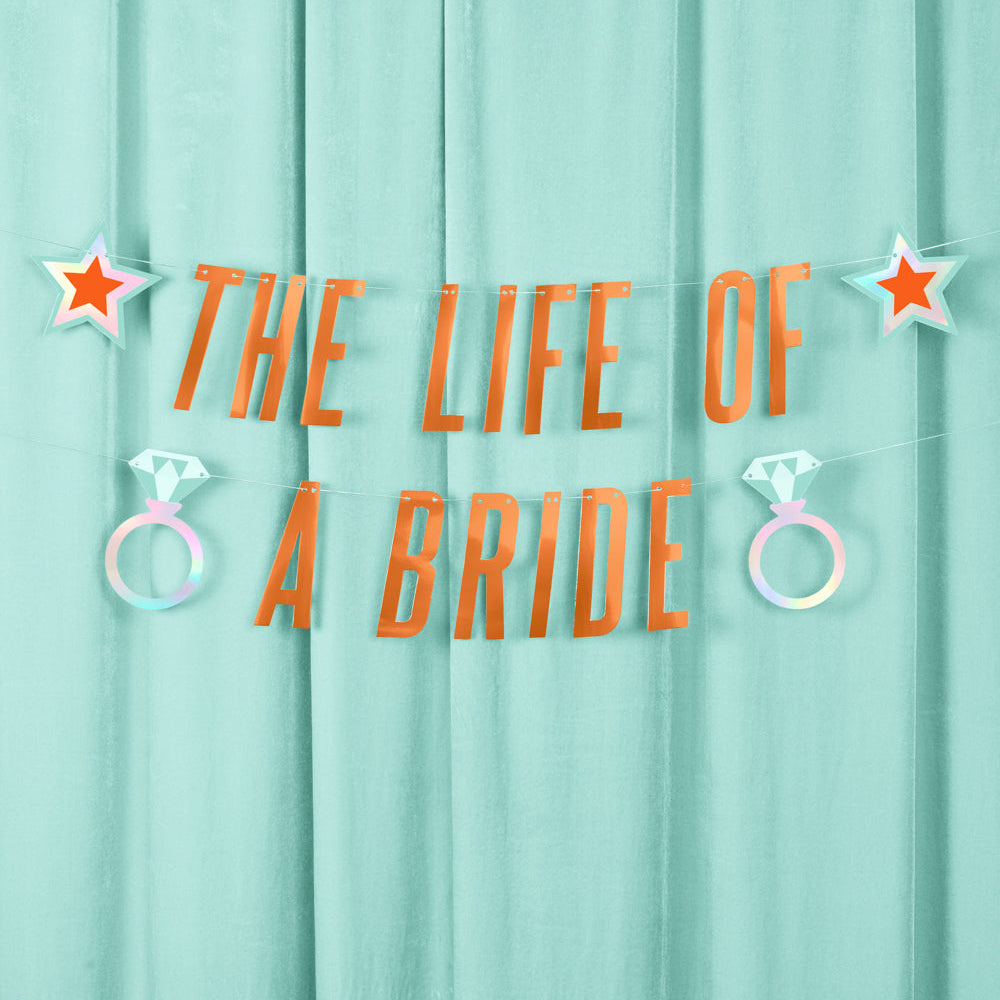 Text 'The Life of a Bride' with star and ring decorations on a light blue curtain background