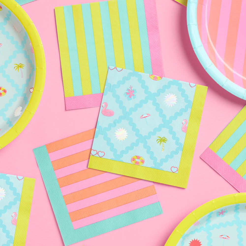 Colorful paper plates and napkins on a pink background