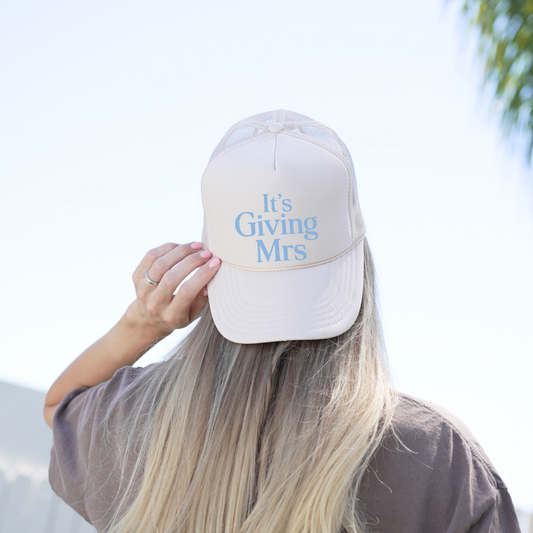 Woman wearing tan It’s Giving Mrs foam front trucker hat outdoors with casual outfit