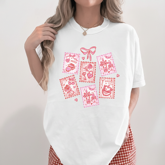 White Valentine stamps tee with pink and red stamp-style graphics, styled with red gingham shorts.