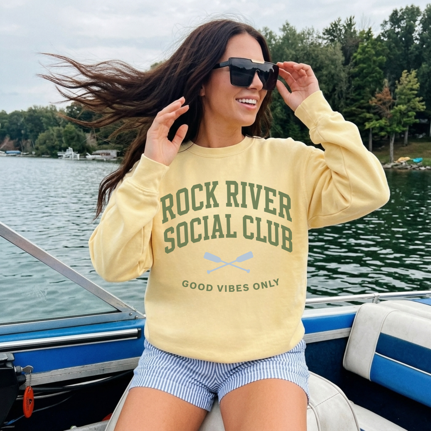 woman wearing yellow rock river social club sweatshirt boat day outfit