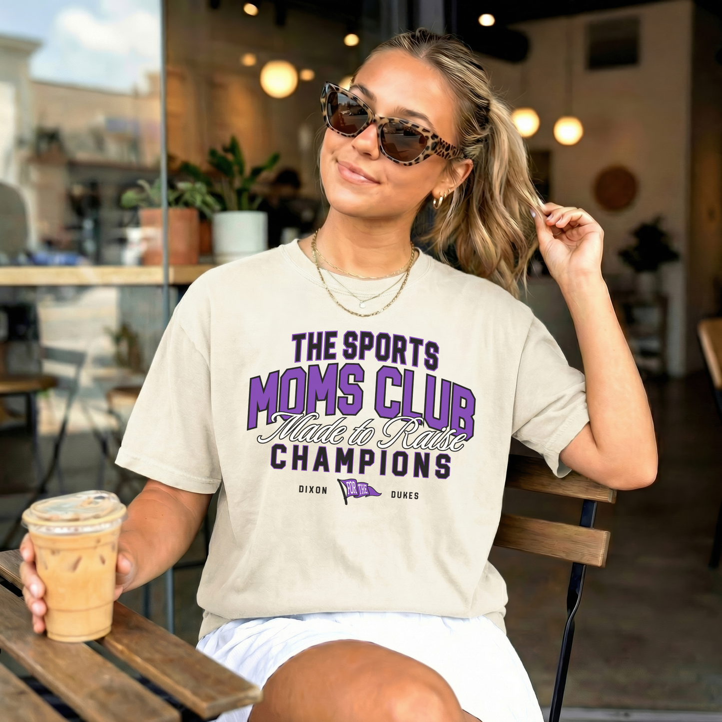 Ivory Comfort Colors Sports Moms Club Dixon Dukes graphic tee styled at coffee shop with sunglasses