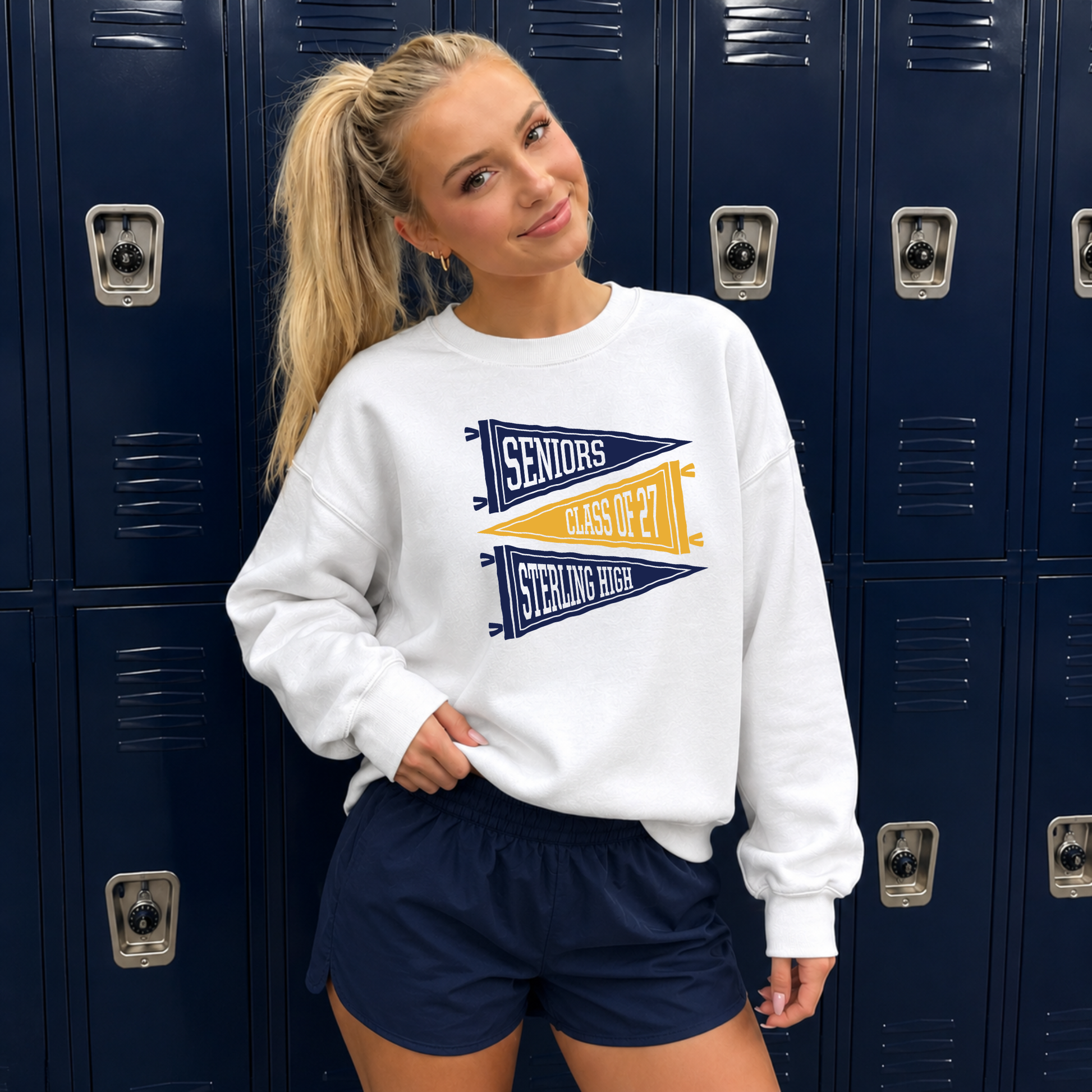 Sterling High Seniors Class of 2027 graphic sweatshirt worn with navy athletic shorts in front of navy school lockers featuring vintage varsity pennant graphics.