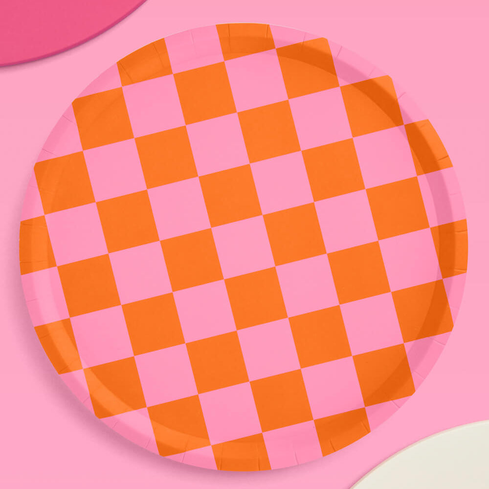 Checkered pink and orange plate on a pink background