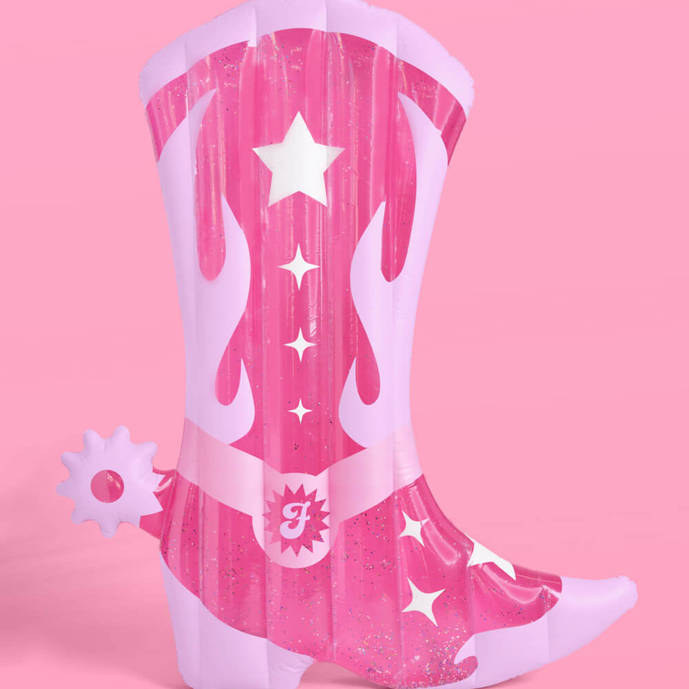 Pink cowboy boot with white stars and a belt on a pink background