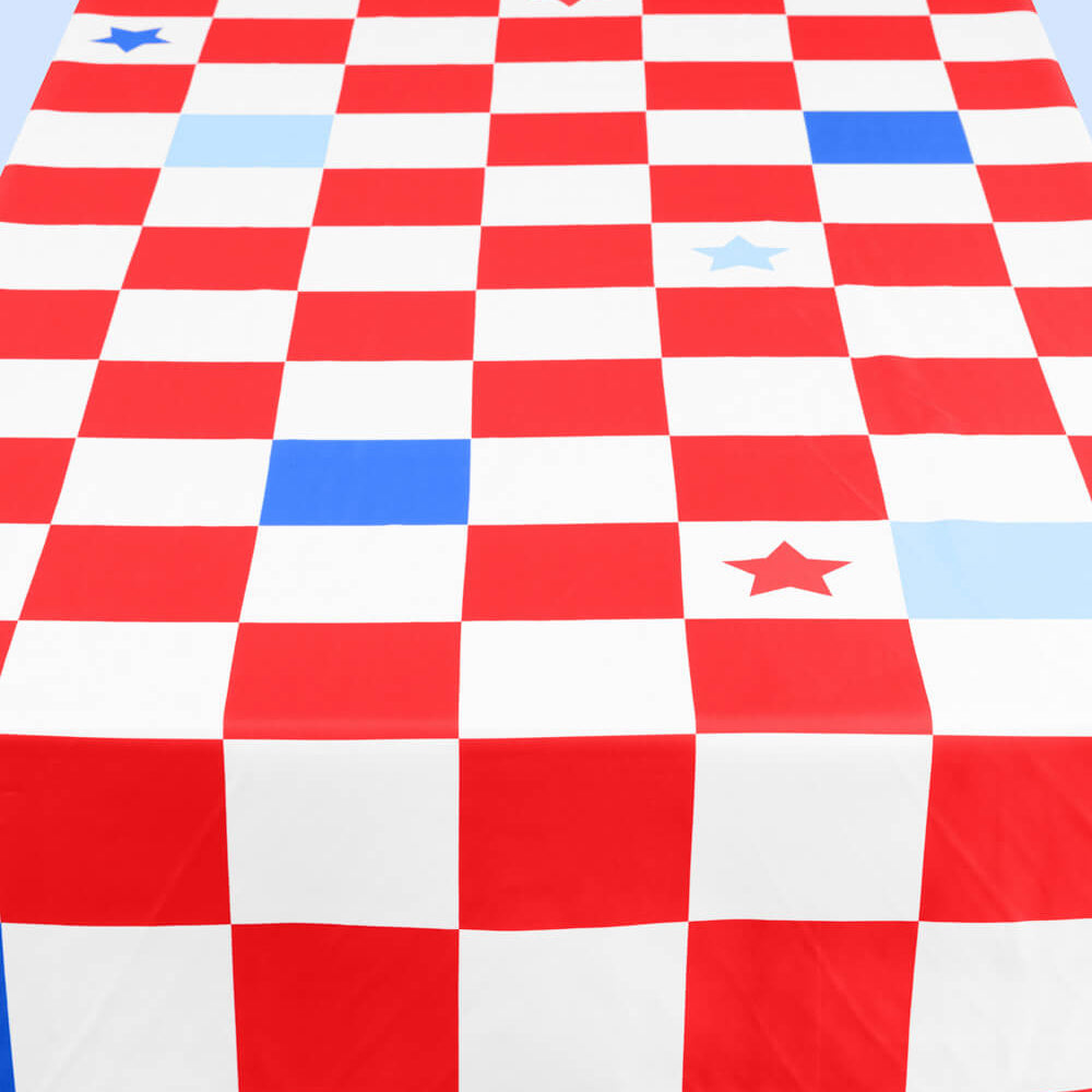 Red, white, and blue checkered tablecloth with star patterns on a flat surface.