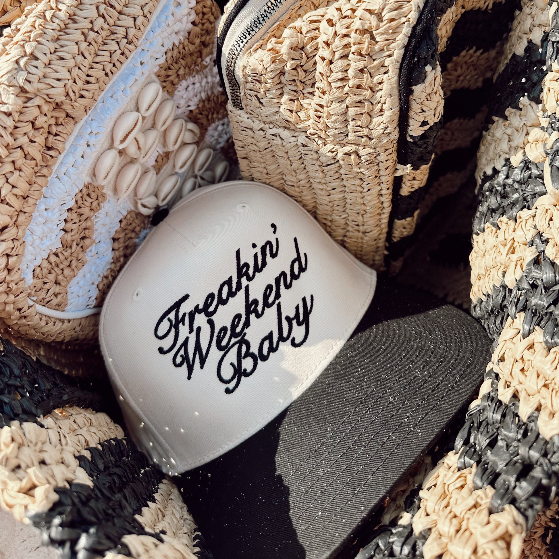 Woven clutch bag with 'Freakin' Weekend Baby' tumbler on a textured surface