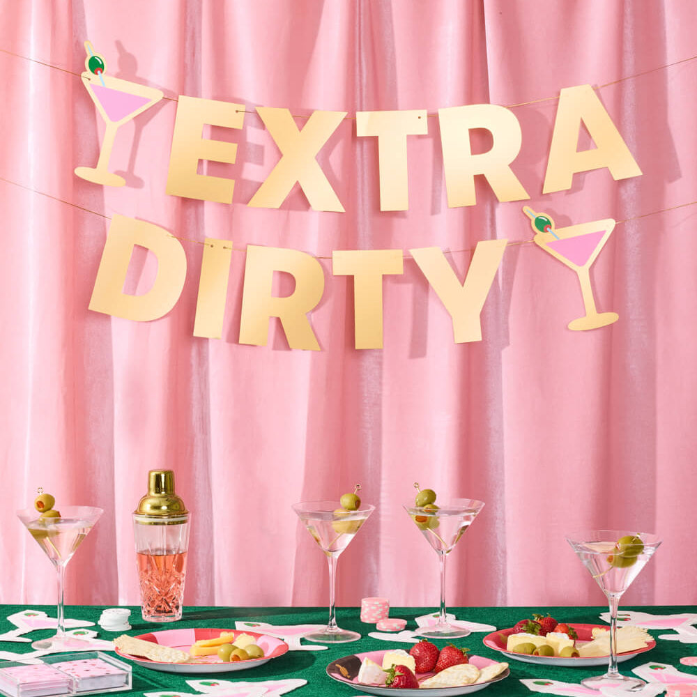 Decorated table with 'Extra Dirty' banner against a pink curtain