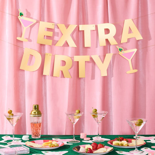 Decorated table with 'Extra Dirty' banner against a pink curtain