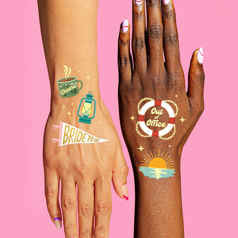 Two hands with temporary tattoos on a pink background