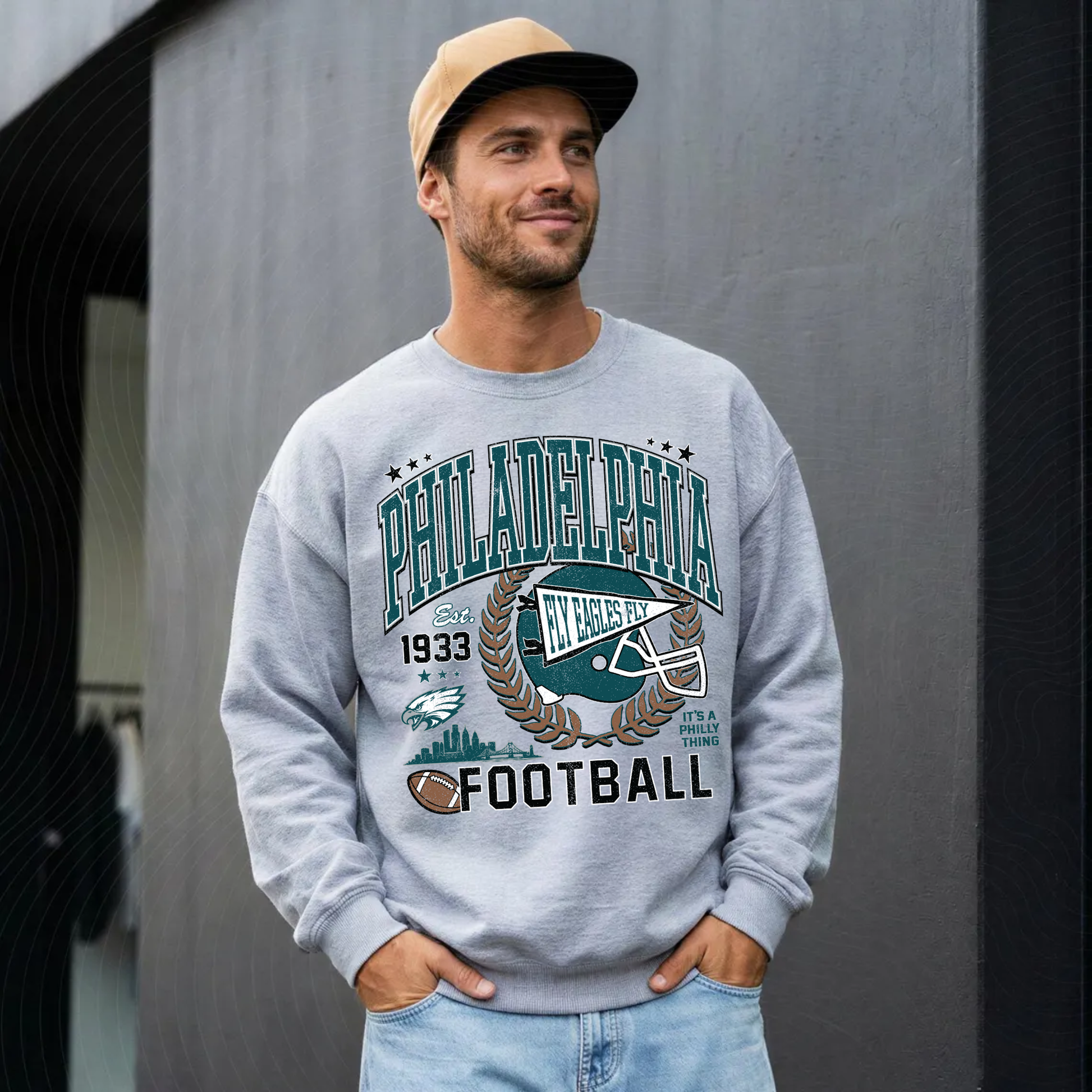 Man wearing heather gray Philadelphia football sweatshirt with vintage green game day graphic
