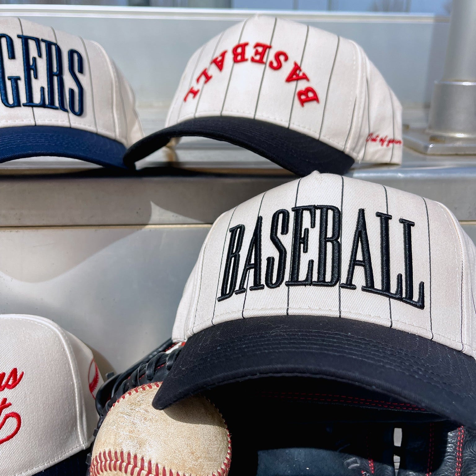 Baseball caps with 'BASEBALL' text and a baseball on a vehicle roof.