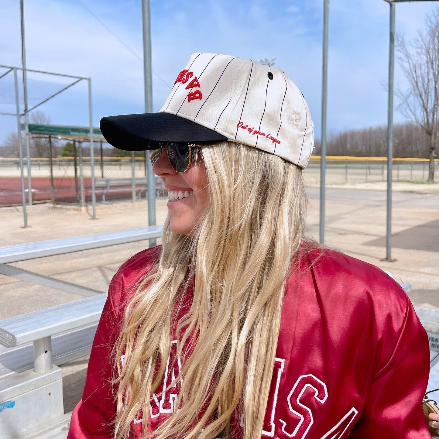 Person wearing a red jacket and cap with 'baseball' logo, standing outdoors.