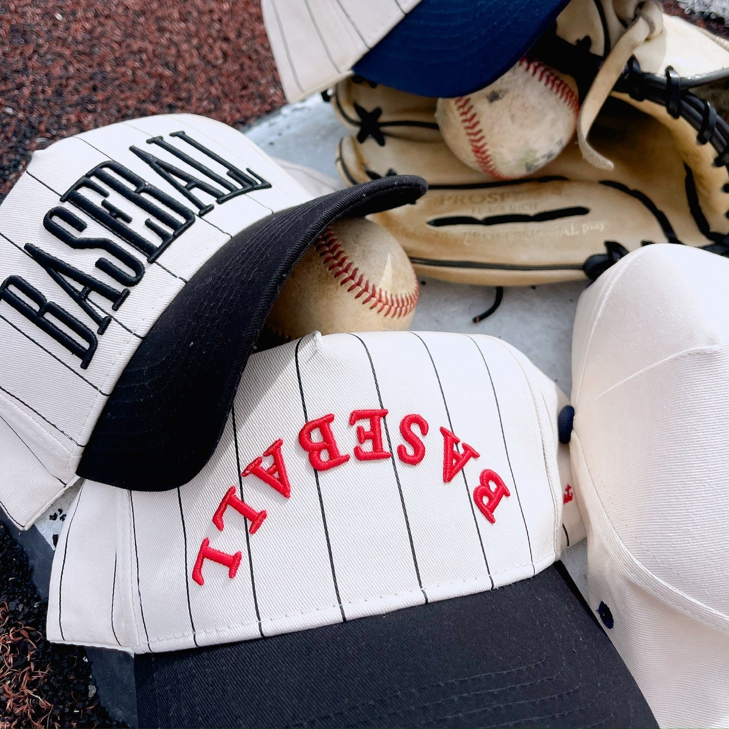 Baseball caps and baseball glove on a textured surface