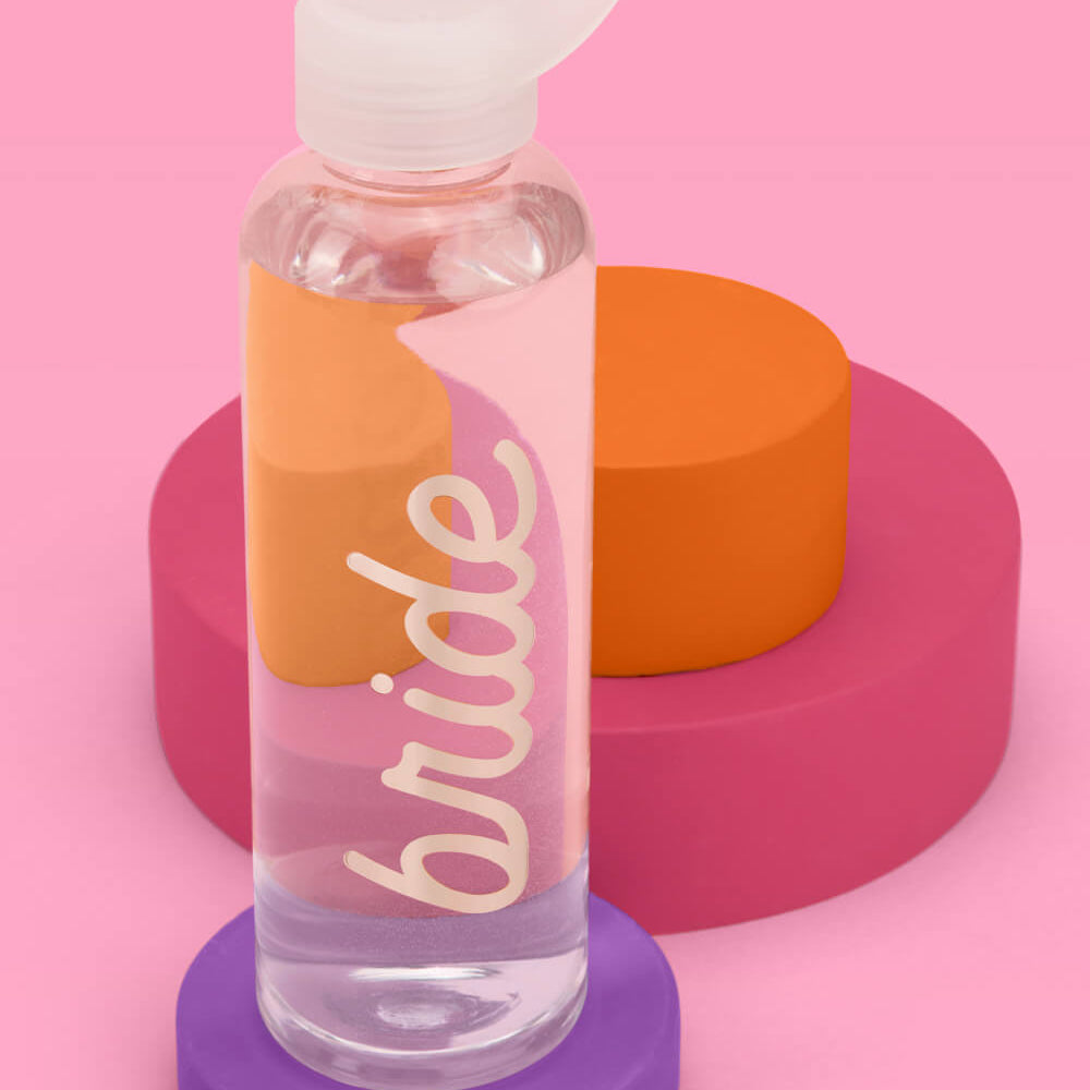 Clear water bottle with 'bride' text on a pink background