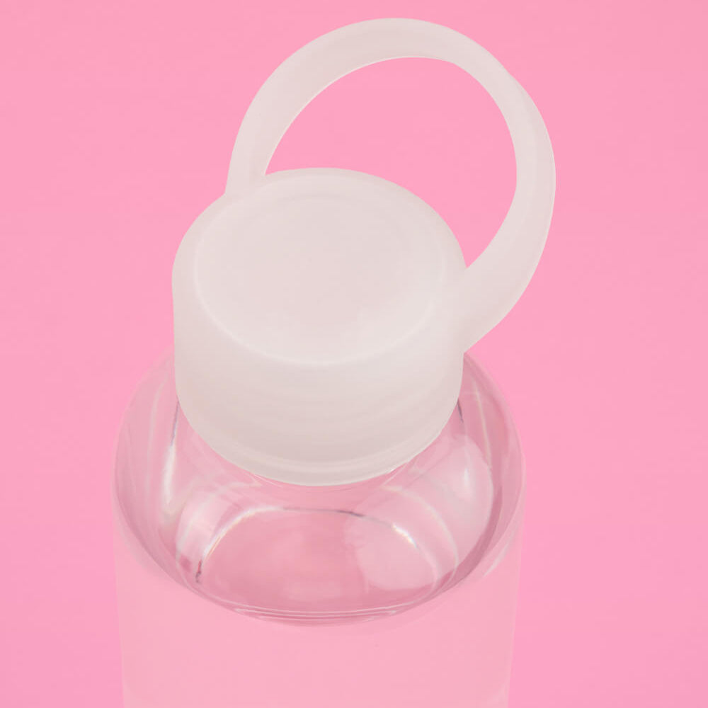 Clear water bottle with a white cap on a pink background
