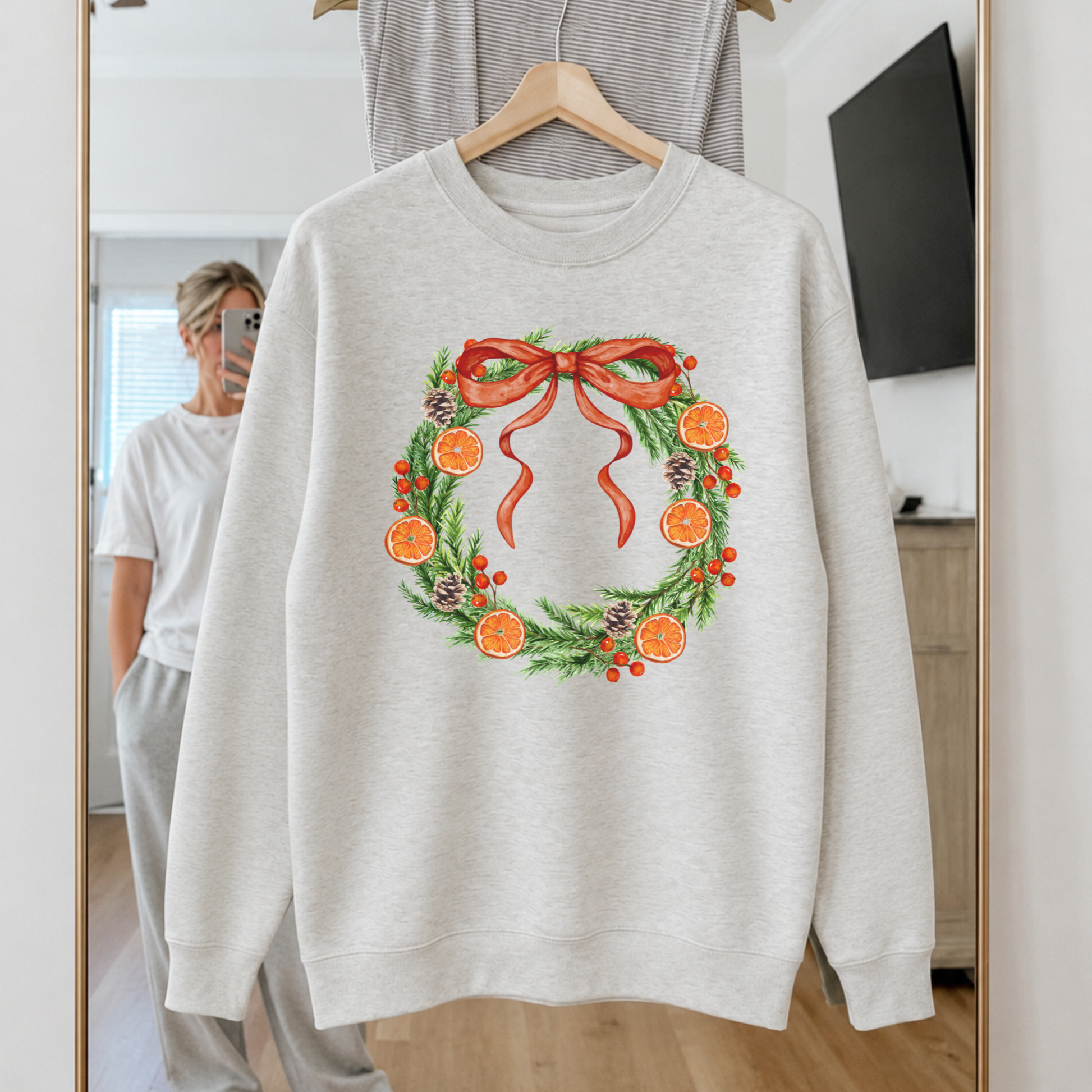 Orange Grove Christmas Wreath premium cream crewneck sweatshirt flat lay featuring evergreen wreath with dried oranges and red bow.
