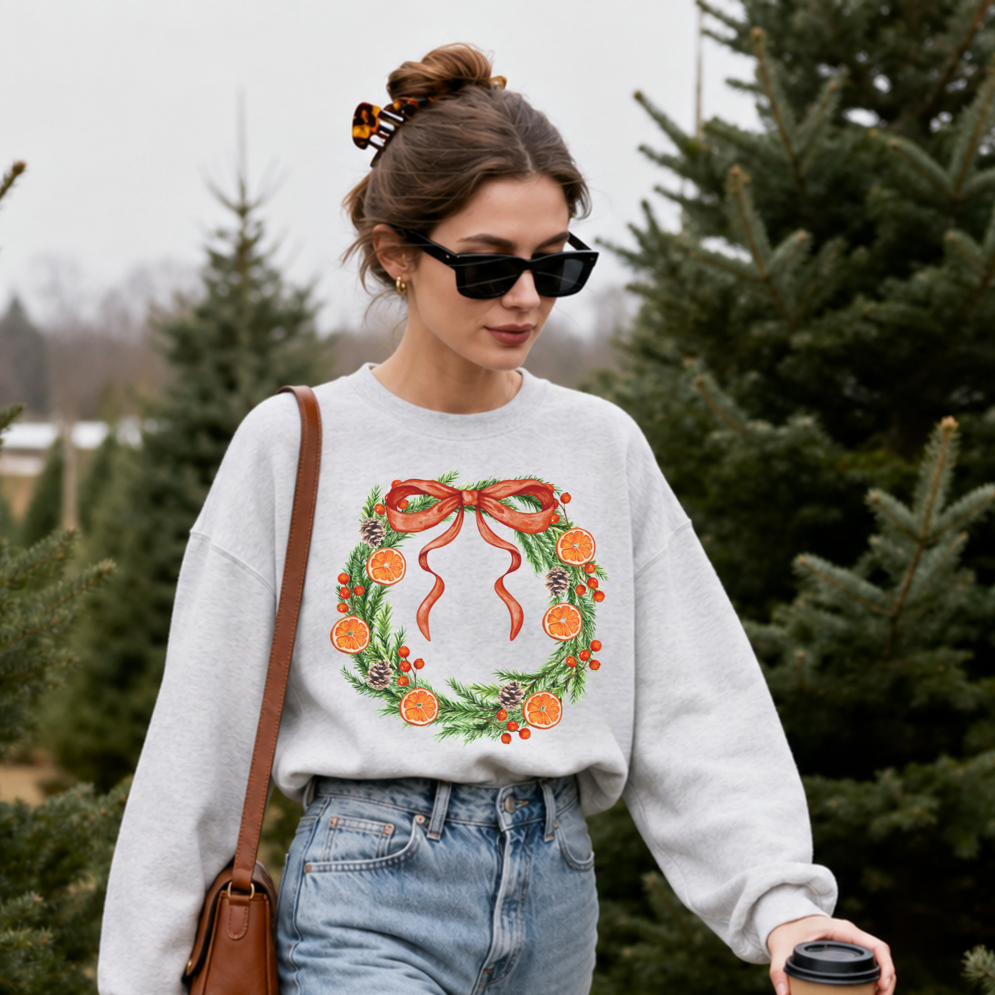 Close-up of woman wearing Orange Grove Christmas Wreath holiday sweatshirt with festive Christmas wreath graphic.