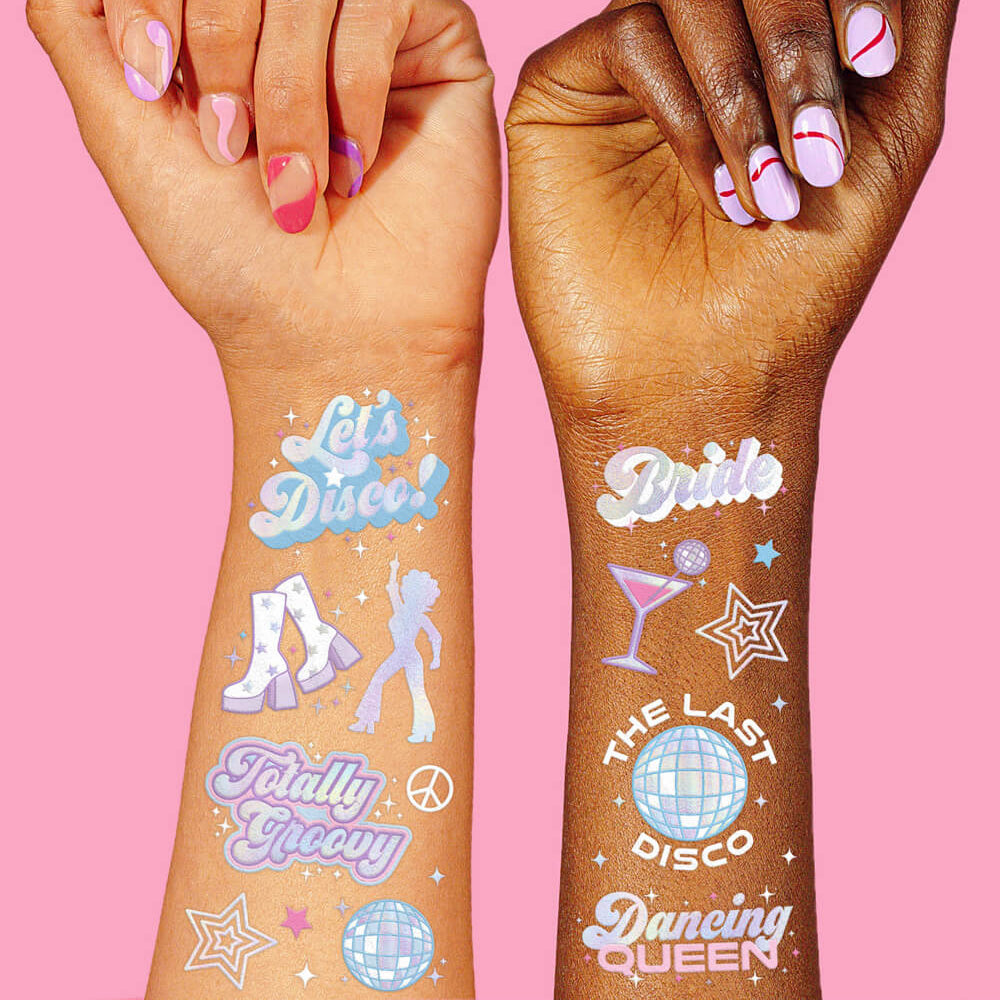 Two hands with colorful temporary tattoos on a pink background