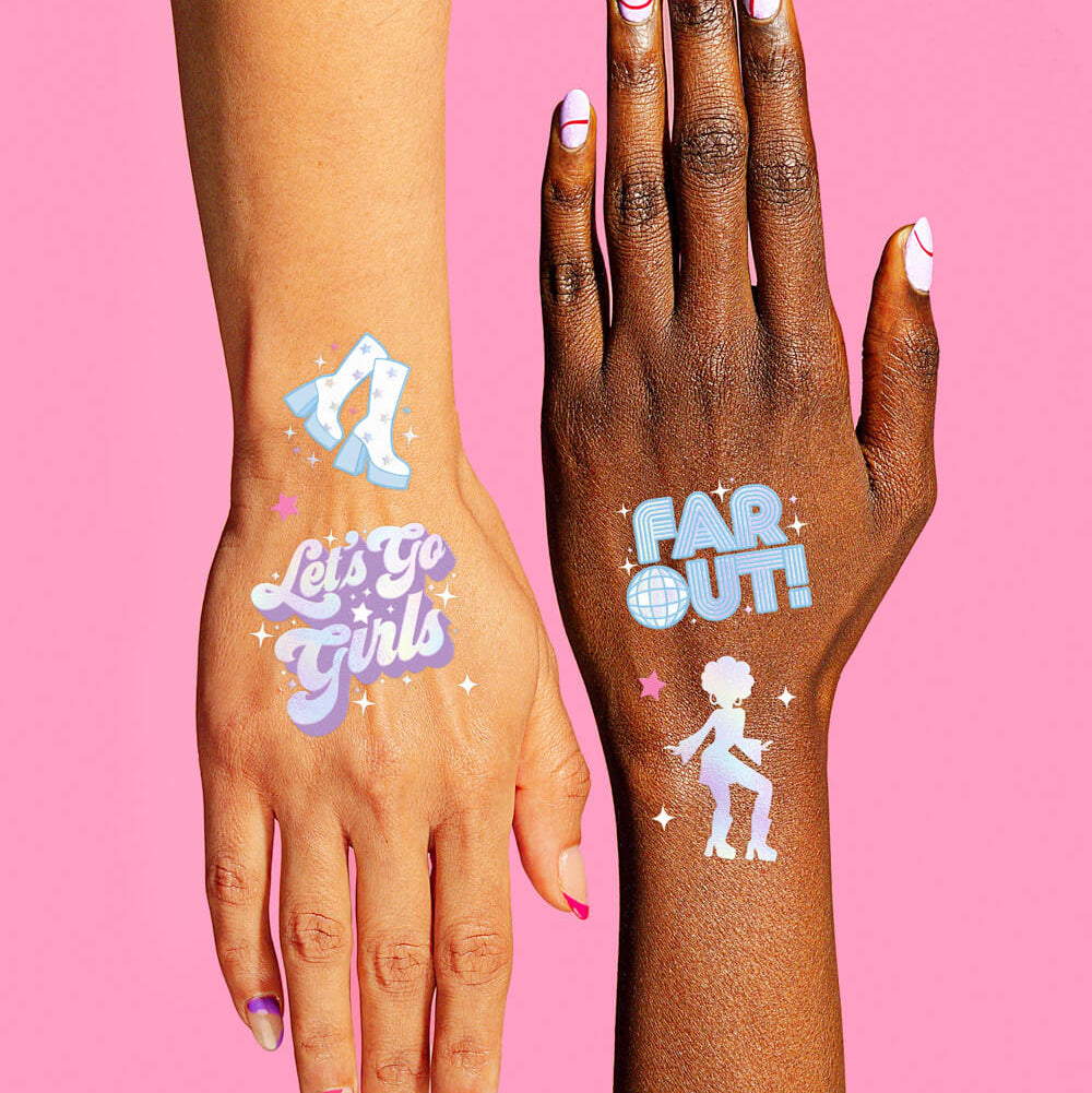 Two hands with colorful temporary tattoos on a pink background