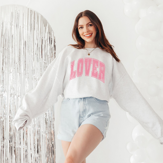 Lifestyle photo of LOVER crewneck styled with denim shorts and casual accessories