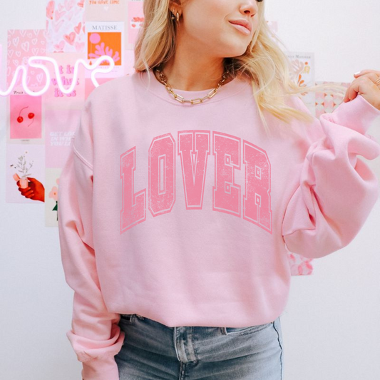 Lifestyle photo of pink LOVER crewneck styled with denim shorts and casual accessories