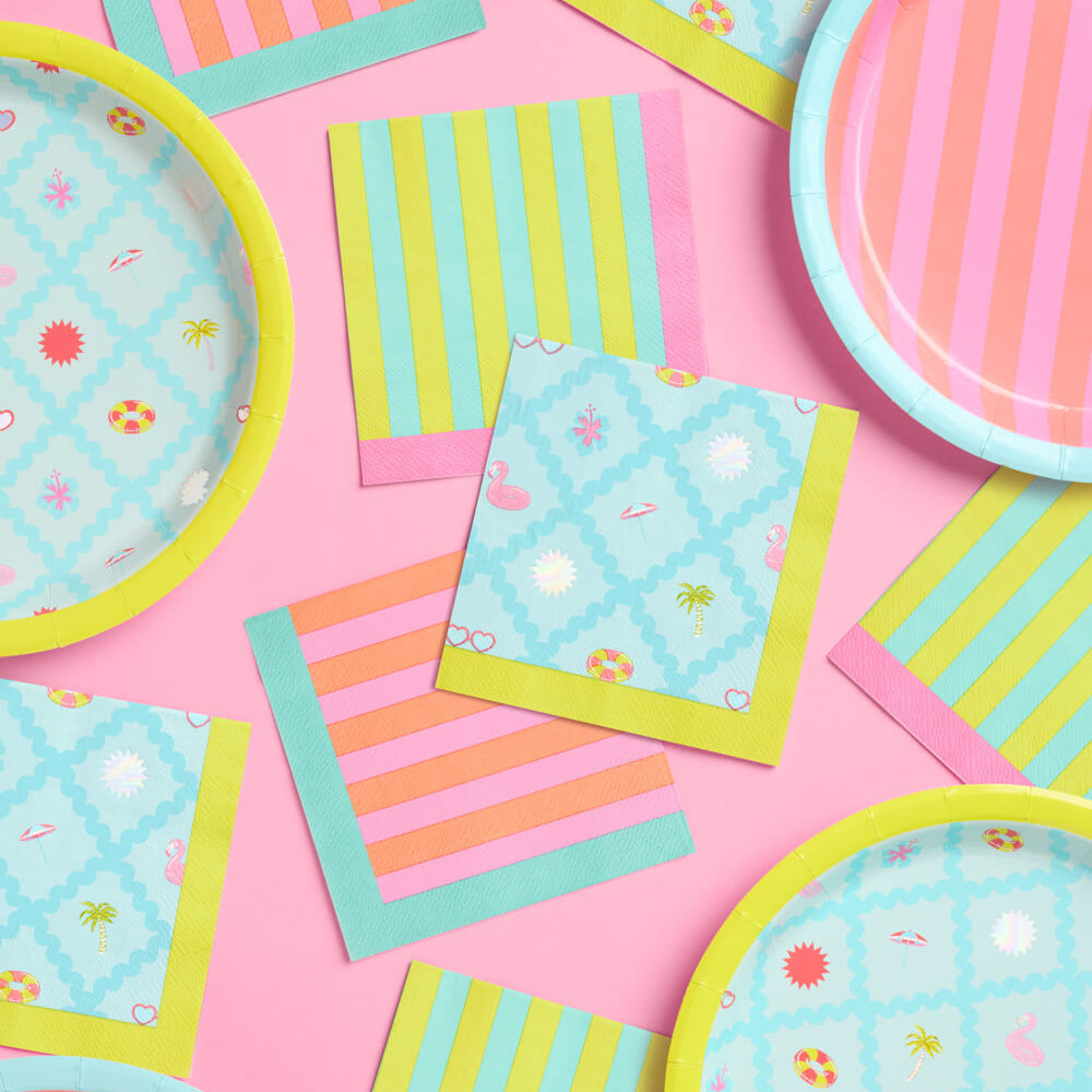 Colorful paper plates and napkins on a pink background