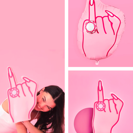 Woman posing with a pink hand-shaped pillow on a pink background