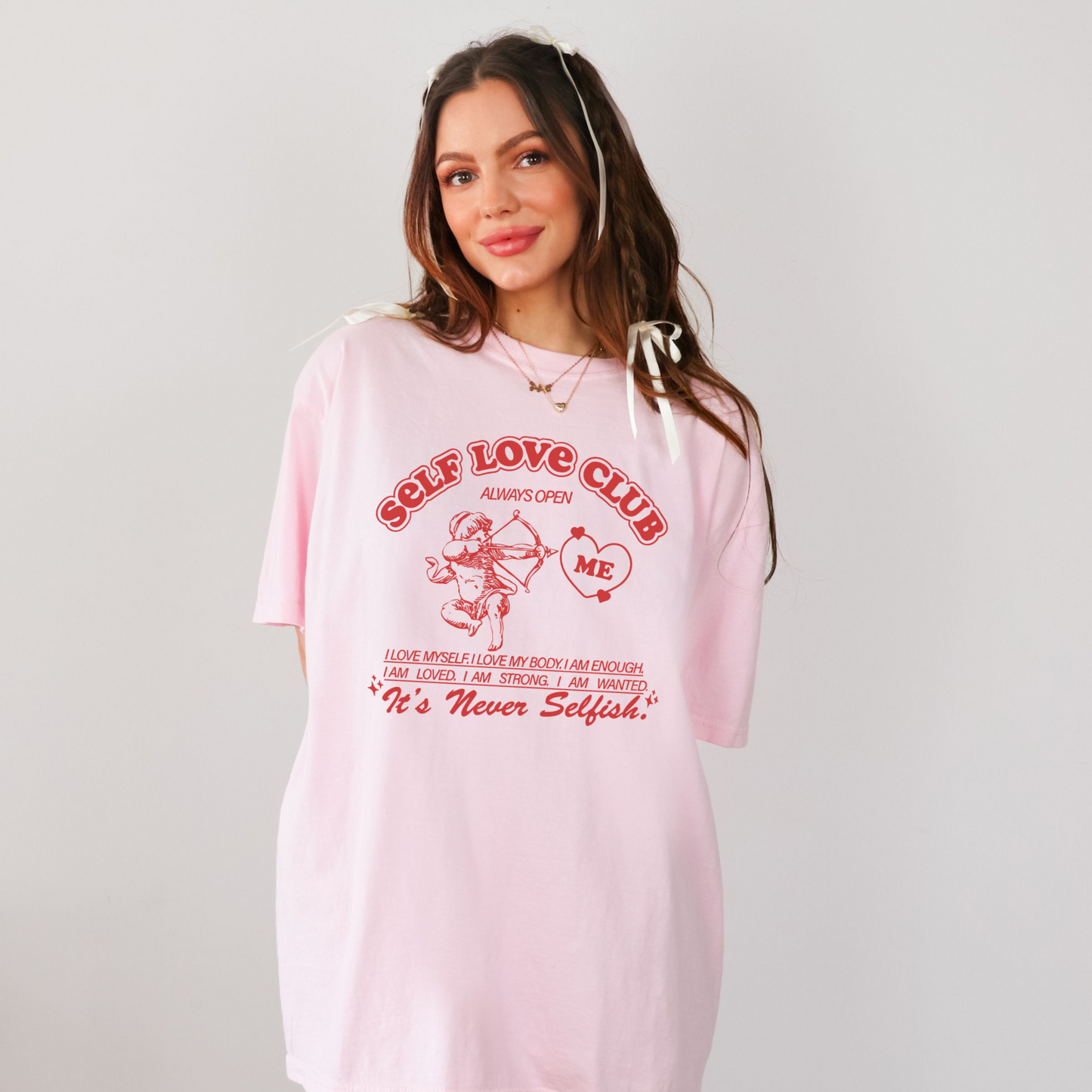 Front view of pink Self Love Club graphic t-shirt with cupid illustration