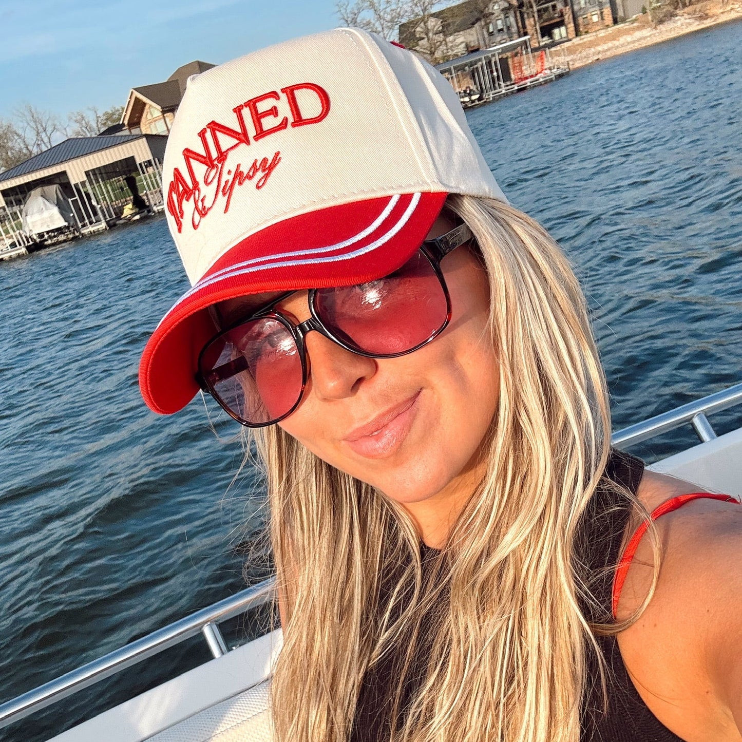 Woman wearing a cap with text on a boat by water