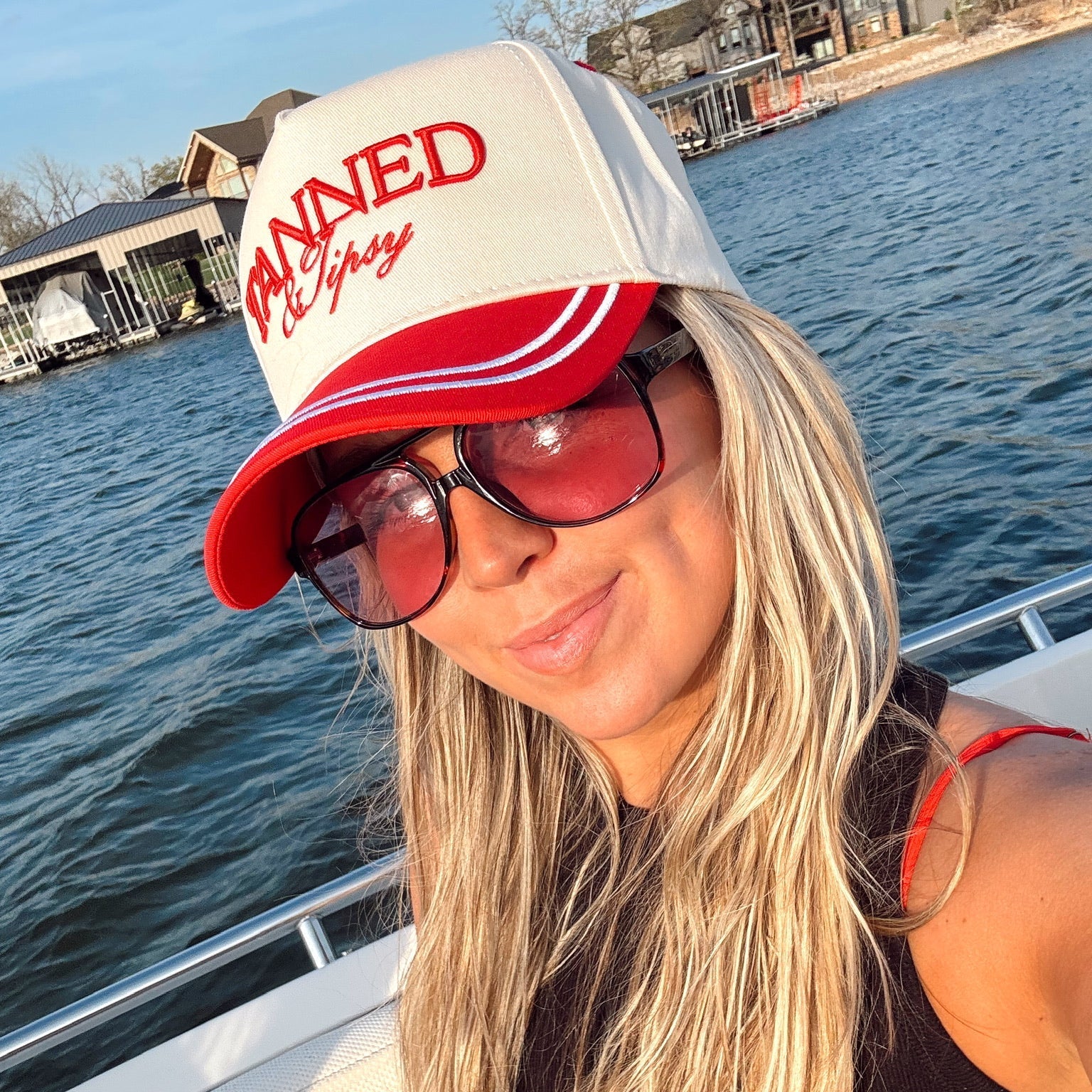 Woman wearing a cap with text on a boat by water
