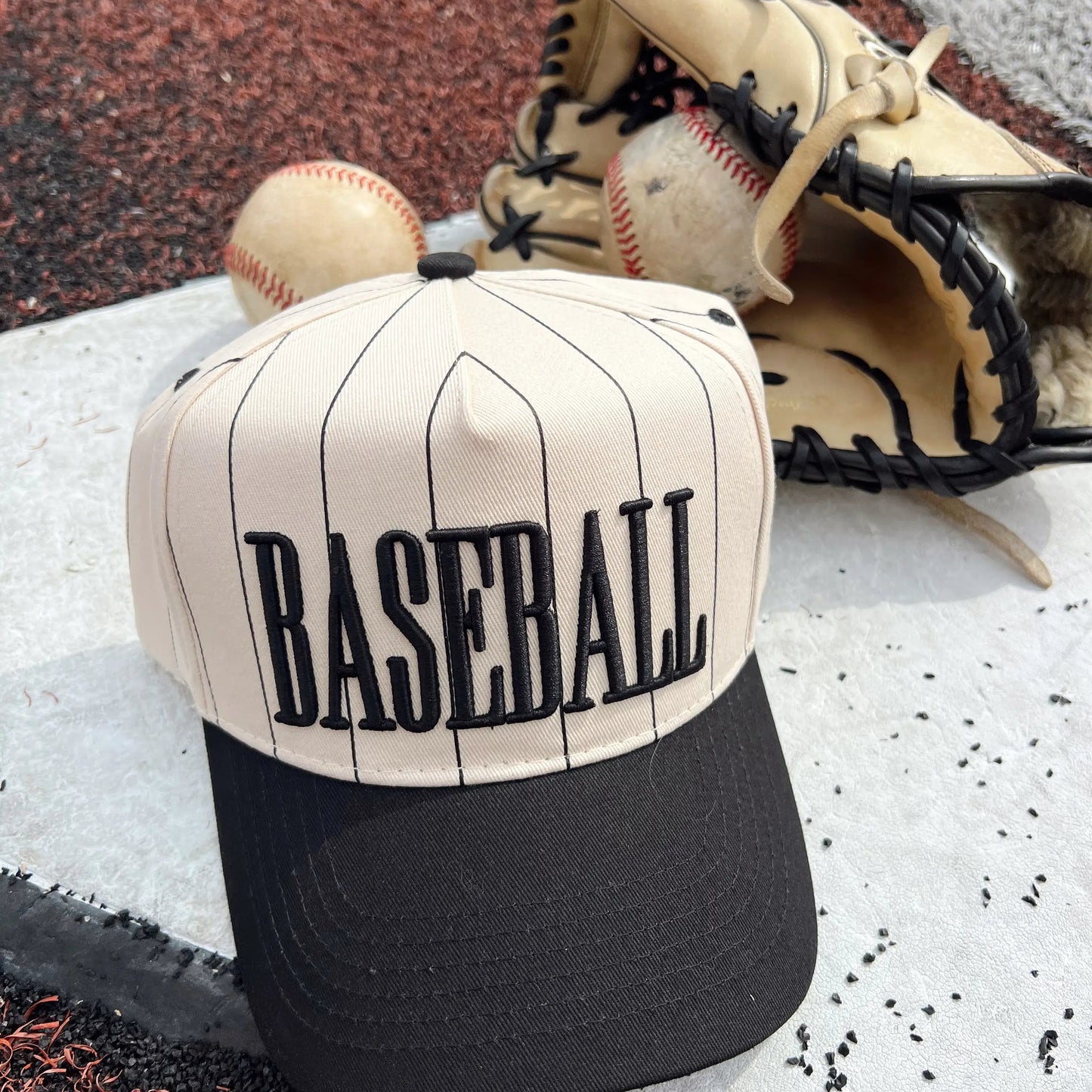 Baseball cap with 'BASEBALL' text, baseball, and glove on a baseball field