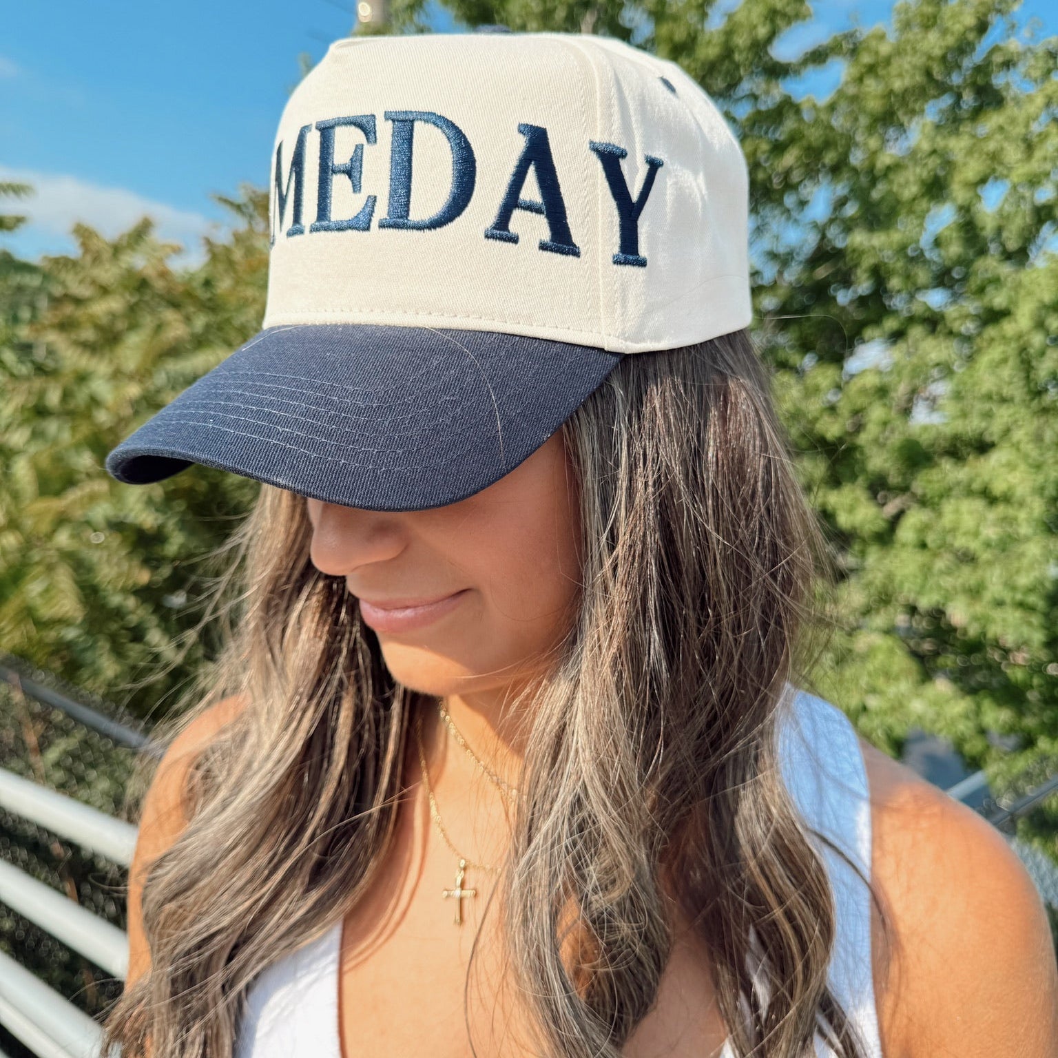 Woman wearing a cap with 'MEDAY' text outdoors