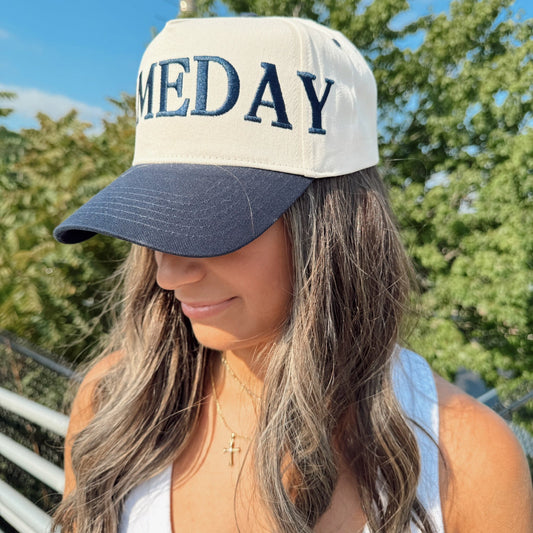 Woman wearing a cap with 'MEDAY' text outdoors