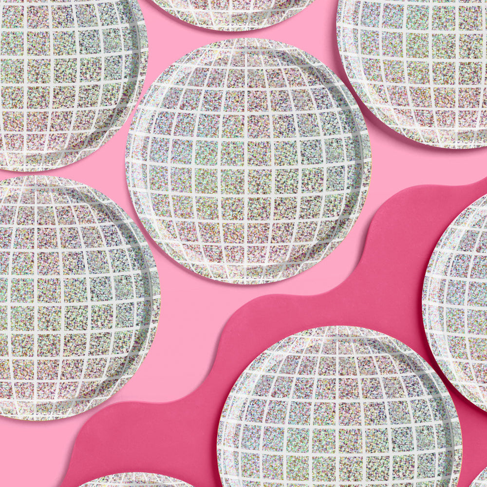 Round, textured paper plates on a pink background