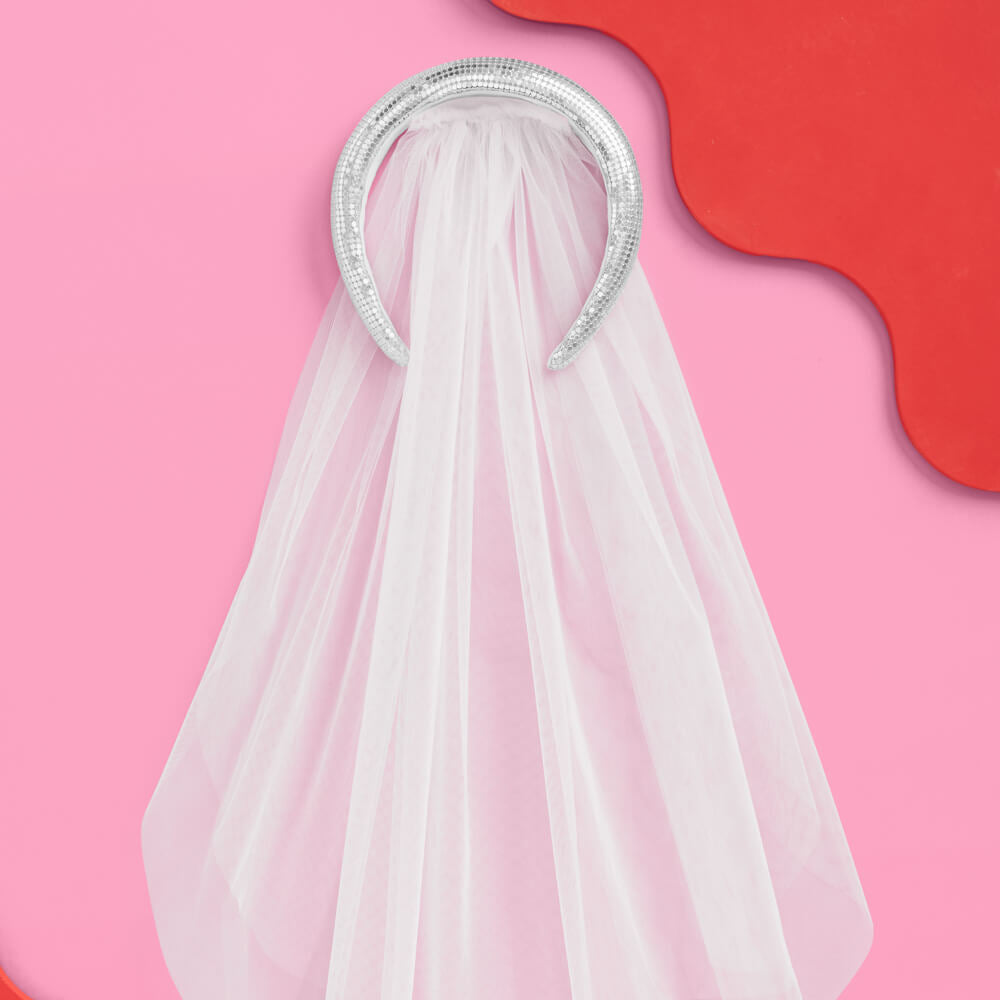 White veil with a silver headband on a pink and red background