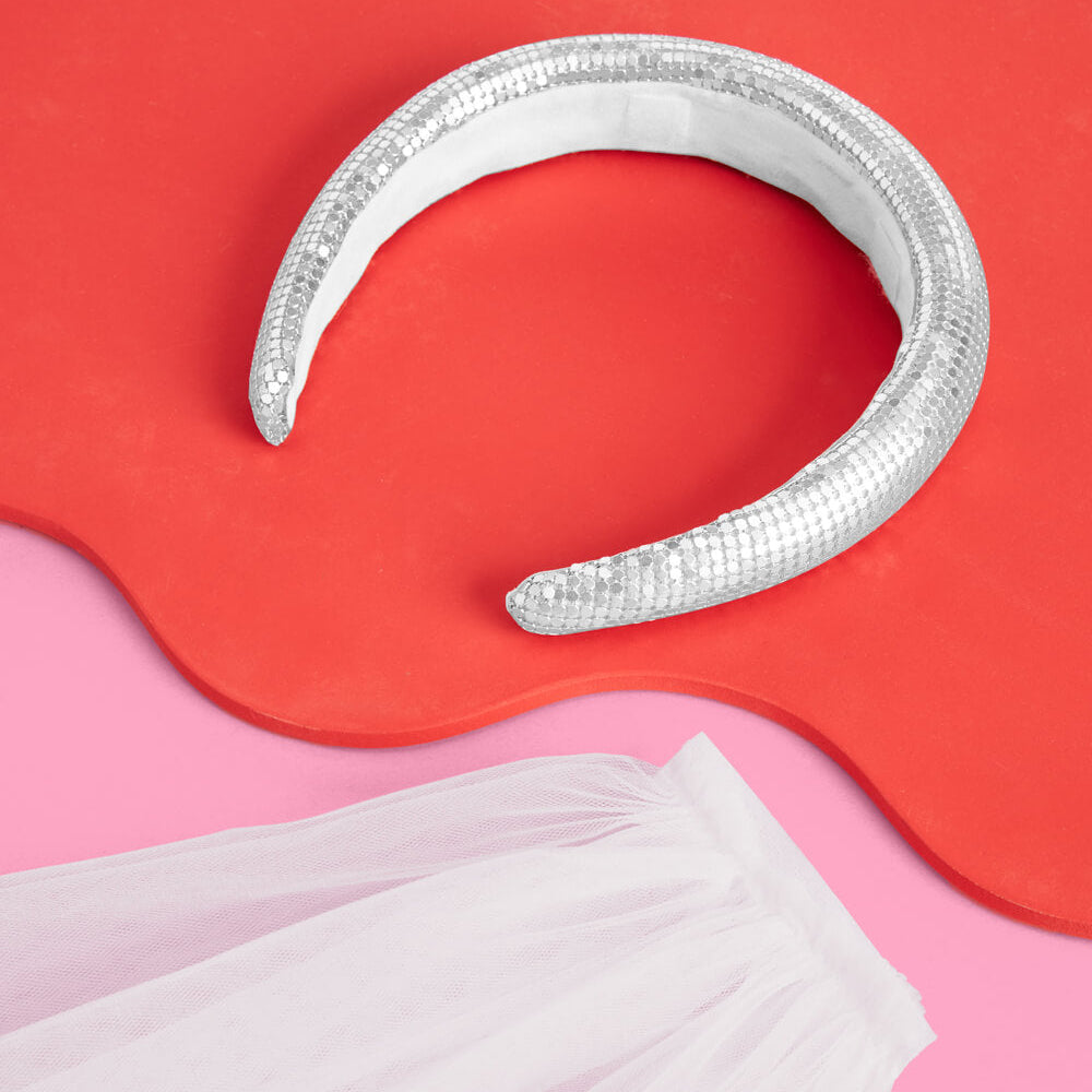Silver metallic snake-like object on a red and pink background