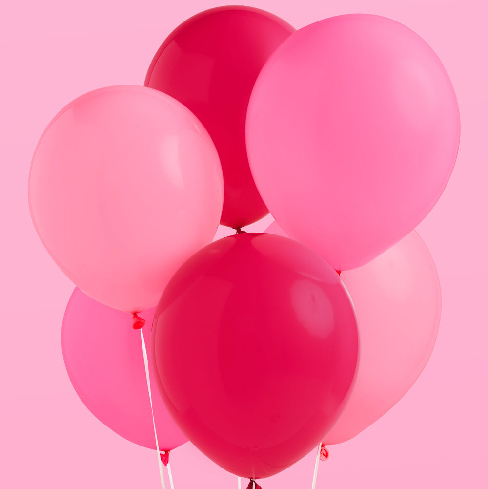 Pink and red balloons against a pink background