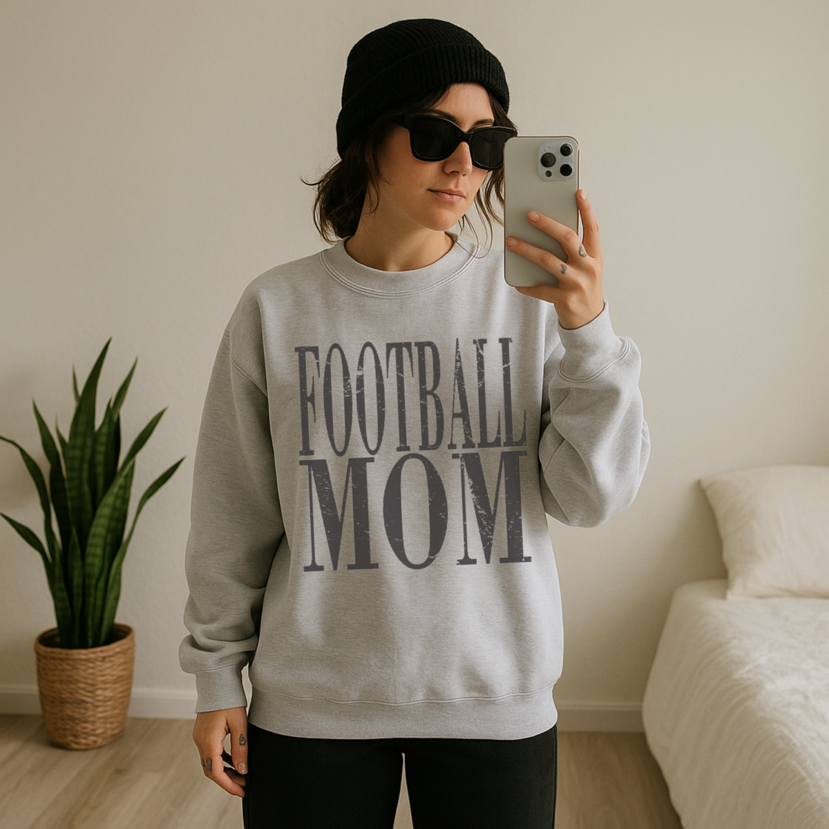 Person wearing a 'FOOTBALL MOM' sweatshirt taking a mirror selfie.