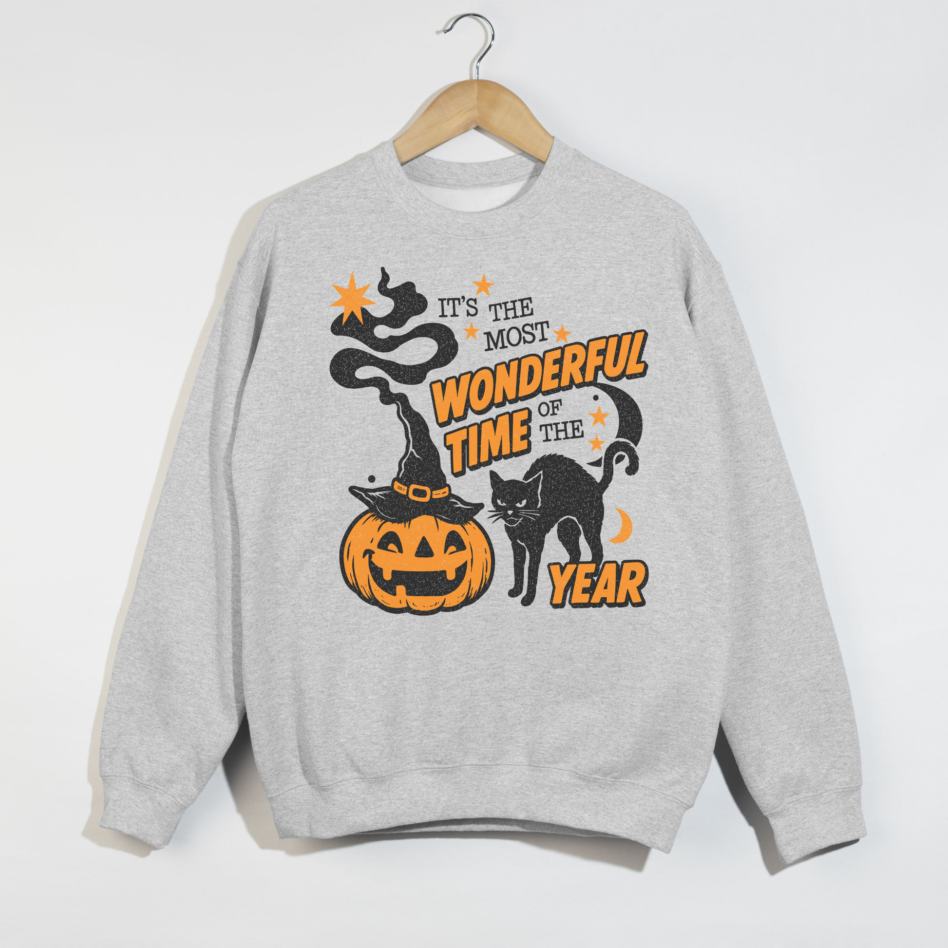 Ash gray Halloween sweatshirt with vintage pumpkin, black cat, witch hat and "It's the Most Wonderful Time of the Year" distressed Halloween design displayed on a wooden hanger.