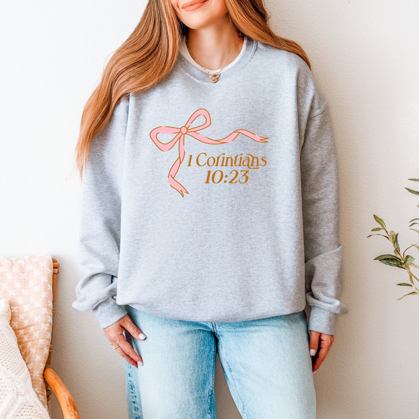 Christian women’s sweatshirt with Bible verse and bow illustration — unisex midweight fleece