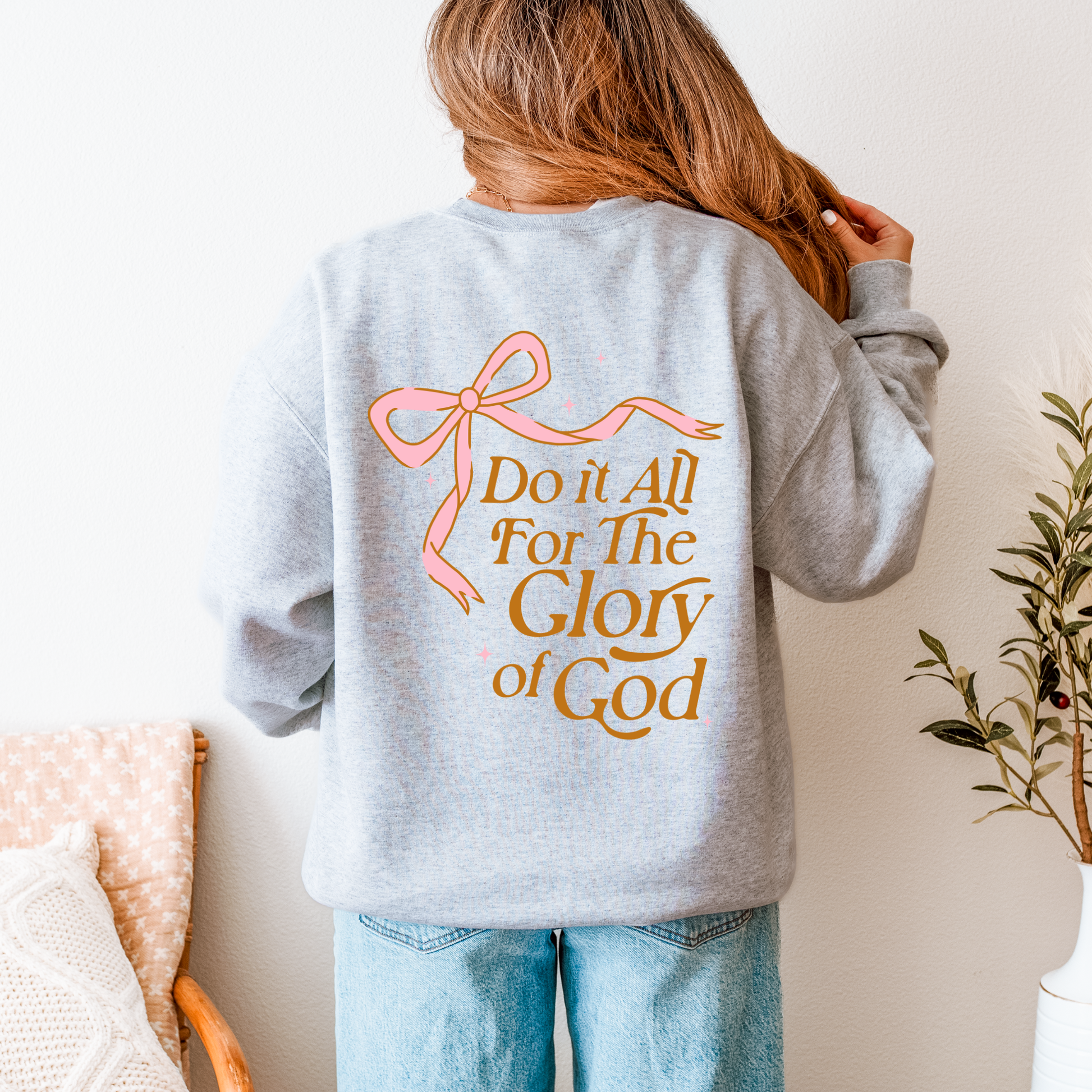 Faith-inspired sweatshirt in light grey with pink bow graphic — scripture design