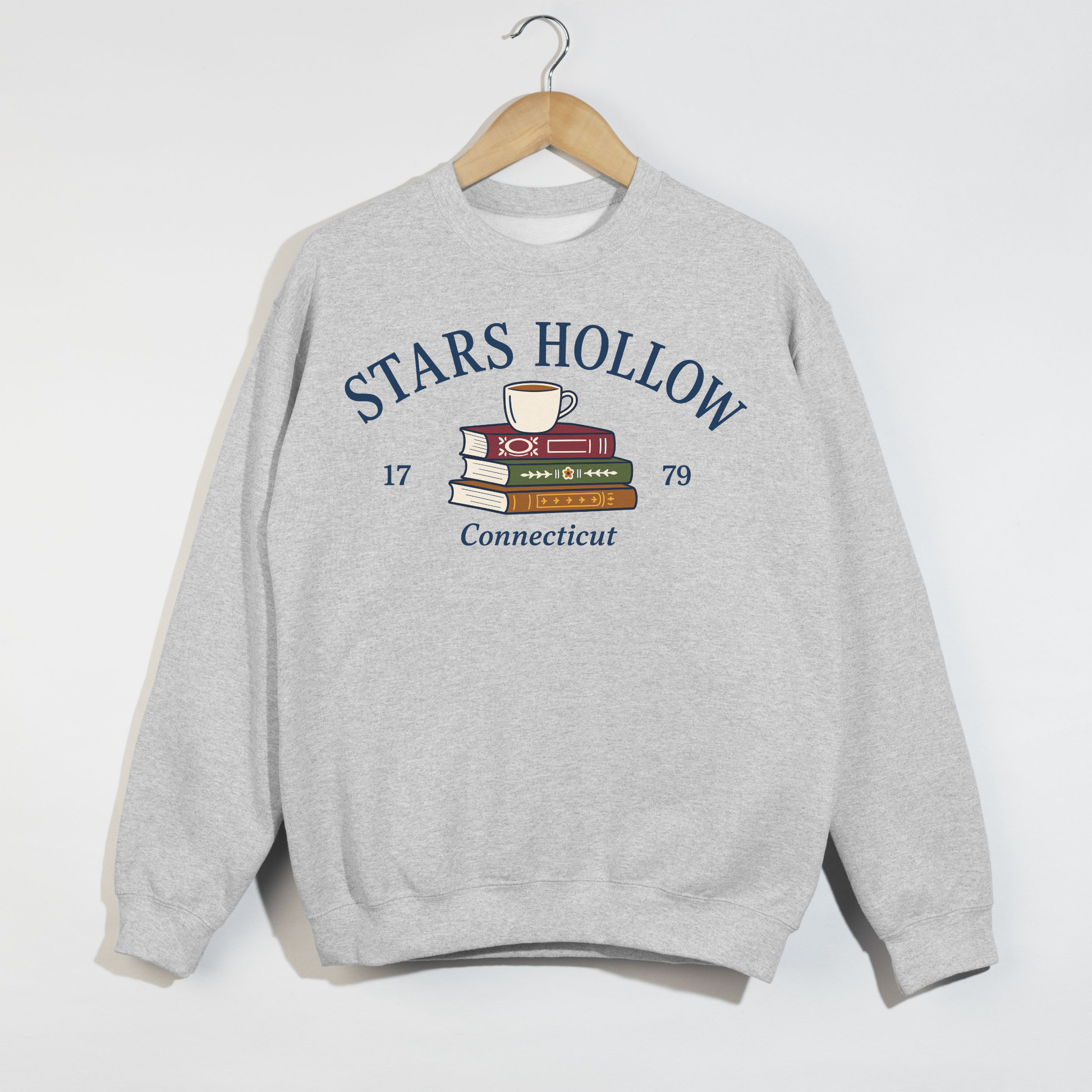 Ash gray Stars Hollow Connecticut crewneck sweatshirt featuring a vintage coffee cup and stacked books graphic.